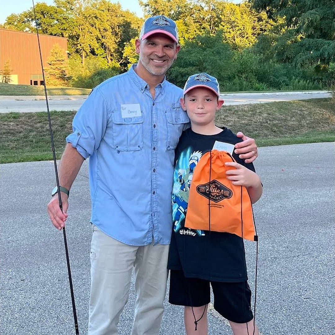 An adult and a young participant together with fishing gear at a Rising Tides Project community event